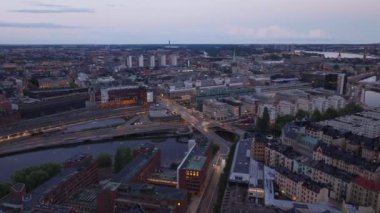 Şehirdeki yol ve köprülerdeki trafiğin hava kaydırağı ve yan görüntüsü. Alacakaranlıkta apartman daireleri. Stockholm, İsveç.