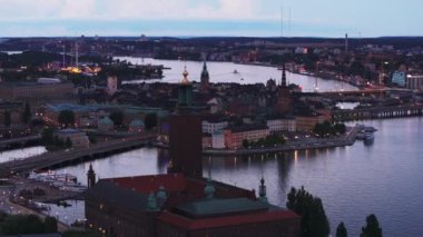 Günbatımında tarihi şehir merkezinde turist manzarası. Stockholms stadshus, Riddarholmskyrkan, Tyska Kyrkan ve adalardaki diğer simgeler. Stockholm, İsveç.