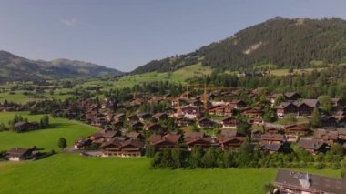 Alp Dağı 'ndaki tipik binaların havadan yükselen görüntüleri. Yeni evin vinçlerle inşaatı. Gstaad, İsviçre.