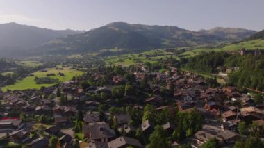 Kasabanın dağ manzaralı havadan görünüşü. Güzel dağlık arazideki tipik binalar. Gstaad, İsviçre.