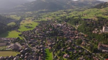 Dağlardaki yolculuğun panoramik görüntüsü. Resimli dağlık arazide küçük bir kasaba. Gstaad, İsviçre.