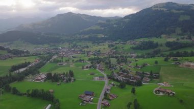 Köyün ya da dağ vadisindeki küçük bir kasabanın hava panoramik görüntüleri. Güzel dağ manzarası. Gstaad, İsviçre.