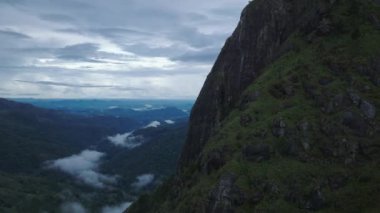 Derin vadi manzarası olan dik kaya duvarları boyunca uçun. Ormandan yükselen sisle sabah manzarası. Ella, Sri Lanka.