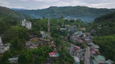 Güzel tropikal yamaçtaki küçük bir kasabada binaların ve sokakların üzerinden ileriye doğru uçar. Ella, Sri Lanka.