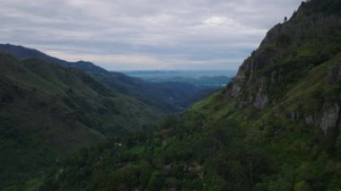 İleri doğru dağ manzarası üzerinde uçar. Dik yamaçlar ve yeşil ağaçları ve bitkileri olan derin vadiler. Ella, Sri Lanka.