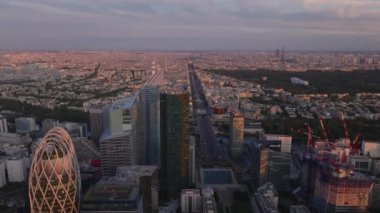 Gün batımında Metropolis 'in panoramik görüntüsünü alıyor. İleri görüşlüler, modern gökdelenlerle La Defense iş bölgesinin üzerinde uçuyor. Paris, Fransa.