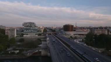 Gün batımında, şehrin çok şeritli caddesindeki trafiğin hava kaydırak ve pan görüntüleri. Paris, Fransa.