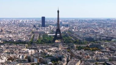 Eyfel Kulesi 'nin, çevresindeki parkın, bahçelerin ve şehirdeki binaların hava kaydırak ve pan görüntüleri. Paris, Fransa.