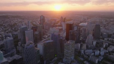 Günbatımına karşı La Defense iş bölgesindeki modern yüksek katlı ofis binalarının hava kaydırak ve pan görüntüleri. Paris, Fransa.