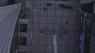 Parvis de la Defense 'ın yukarıdan aşağı görüntüleri. Günbatımında modern ticaret bölgesinde büyük bir meydan. Halka açık alanda yürüyen insanlar. Paris, Fransa.