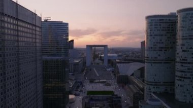 İleri, modern kentsel bölgenin üzerinde uçar. La Defense 'daki gökdelenler ve alacakaranlıkta finans merkezi. Büyük meydan ve Büyük Arche de la Defense. Paris, Fransa.