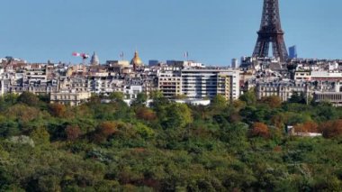 Parktaki ve etrafındaki binalardaki ağaçların hava manzarası. Tarihi şehir merkezinin panoramik manzarasının yükselişi. Paris, Fransa.