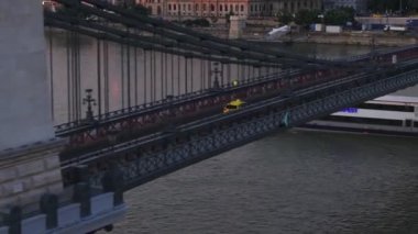 Sarı taksi eski köprüden geçiyor. Tuna Nehri 'nde bir gemi köprünün altından geçiyor. Budapeşte, Macaristan.