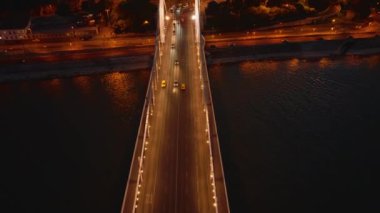 Akşam kentinde Tuna Köprüsü 'nde giden aracın izini sürüyorum. Aydınlanmış sokaklar ve düşük trafik. Budapeşte, Macaristan.