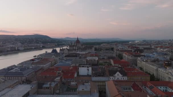 黄昏时分 在历史名城中心的建筑物上方 向前飞去 多瑙河畔匈牙利议会上美丽的新哥特式建筑 匈牙利布达佩斯 — 图库视频影像
