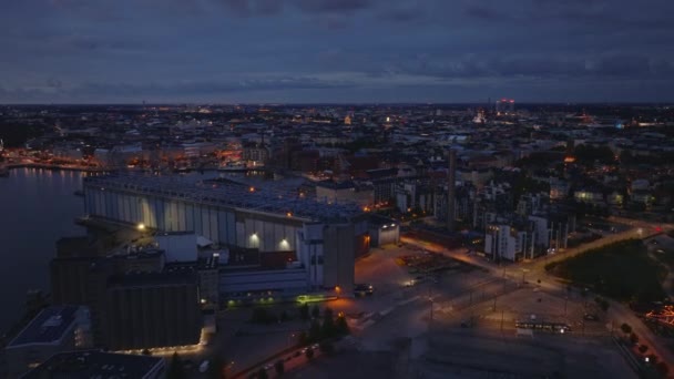 その後 夕暮れ時に造船所の上を飛びます 曇った空の街並みを眺める空中パノラマの夜景 ヘルシンキ フィンランド — ストック動画