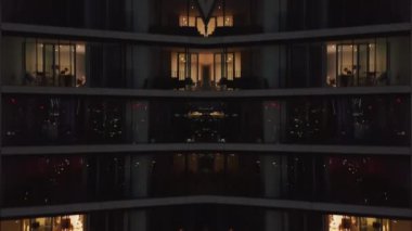 Konut kulesindeki dairelerin yakın çekim görüntüleri. Akşamları modern gökdelen boyunca uçun. Soyut bilgisayar efekti dijital oluşturulmuş görüntüler.