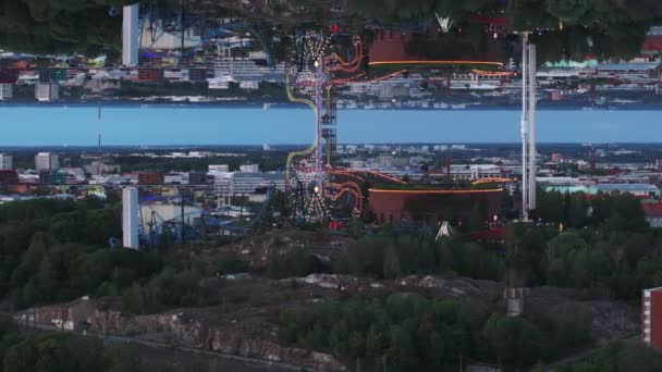 夕暮れのアミューズメントパークの空中スライドとパン映像 ラナマキパークの美しいアトラクション ヘルシンキ フィンランド 抽象的なコンピュータ効果デジタル構成された映像 — ストック動画