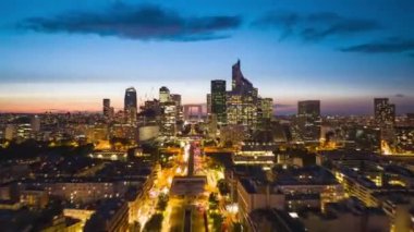 Günbatımında modern La Defense bölgesinin hava hızlandırılmış görüntüleri. İleri uçaklar, akşam kentinde kalabalık çoklu şeritli yolun üzerinde uçar. Paris, Fransa.