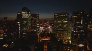 Gece vakti La Defense ilçesindeki yüksek binaların hava yükselen görüntüleri. İş kulelerindeki ışıklı pencereler. Paris, Fransa.