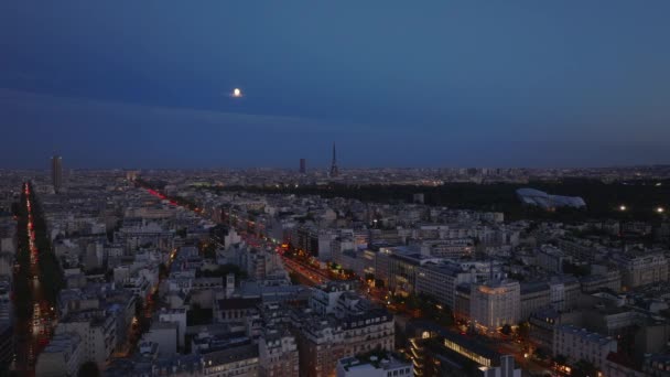 忙しい通りや有名な観光名所を持つ夜の大都市の空中パノラマビュー 月は都市の上空に フランス — ストック動画