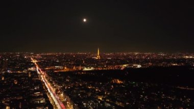 Büyük şehrin havadan panoramik görüntüsü. Popüler Eyfel Kulesi 'nin tepesinde dönen spot ışıklarıyla aydınlandı. Paris, Fransa.