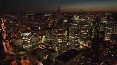 La Defense gökdelenlerinin hava kaydırağı ve pan görüntüsü. Metropolis 'teki bir grup yüksek katlı ofis binaları geceleyin Paris, Fransa.