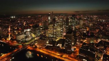 Gece vakti La Defense iş merkezinin sinematik görüntüsü. Pencereleri ışıklandırılmış yüksek katlı ofis binaları. Paris, Fransa.