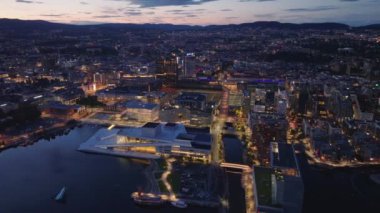 Opera Oslo 'nun ve sahil boyundaki modern tasarım binalarının hava görüntüleri. Şehir alacakaranlık gökyüzüne karşı. Oslo, Norveç.