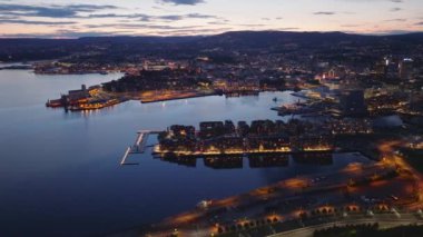 Suni yarımadadaki modern Sorachiutstikkeren ilçesinin havadan panoramik görüntüsü. Alacakaranlıkta aydınlatılmış sokaklar ve binalar. Oslo, Norveç.