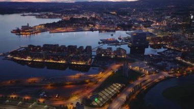 Alacakaranlıkta Oslo fiyort kıyısındaki yerleşim yerinin yüksek açılı manzarası. Yukari egilerek aksam manzarasini göster. Oslo, Norveç.