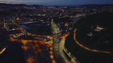 Gece şehrinin hava panoramik görüntüsü. Aydınlatılmış yollarda trafik. Demiryolu rayları ve altyapı. Oslo, Norveç.