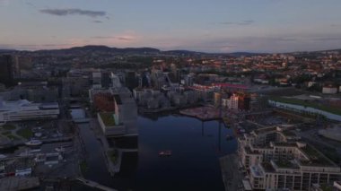 Günbatımında eski limandaki modern yerleşim yerinin hava panoramik manzarası. Rıhtımda kasaba inşaatı. Oslo, Norveç.