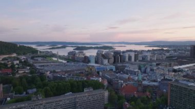 Alacakaranlıktaki rıhtımın havadan panoramik manzarası. Tren istasyonundaki çok katlı binalar. Oslo, Norveç.