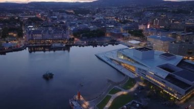 Koydaki yüksek açılı su manzarası ve gelecekteki Opera Binası 'nın etrafında gezinti. Alacakaranlıkta şehir manzarasını göster. Oslo, Norveç.
