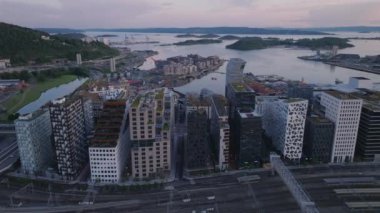 Arka planda Oslo fiyordundaki kentsel bölge ve su yüzeyinin havadan görünüşü. Modern tasarım konut binaları sırasının kayması. Oslo, Norveç.