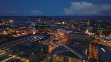 İleri, gece şehrinin üzerinde uçar. Central tren istasyonunun etrafındaki caddeler ve meydanlar aydınlandı. Helsinki, Finlandiya.