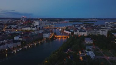 Şehrin su bölgesindeki aydınlatılmış köprünün hava kaydırağı ve pan görüntüsü. Akşam manzarası. Helsinki, Finlandiya.