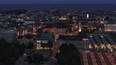 Aydınlatılmış platformlarla şehir merkezi ve şehir merkezinin akşam görüntüsü. Helsinki, Finlandiya.