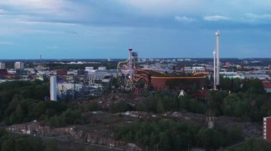 Alacakaranlık 'taki Linnanmaki eğlence parkındaki şehir merkezinin hava görüntüleri. Popüler eğlence parkında adrenalin etkisi. Helsinki, Finlandiya.