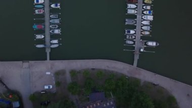 Limandaki uzun rıhtımlara demirlenmiş teknelerin en üstteki görüntüleri. Sakin su yüzeyi ve damarlar. Helsinki, Finlandiya.