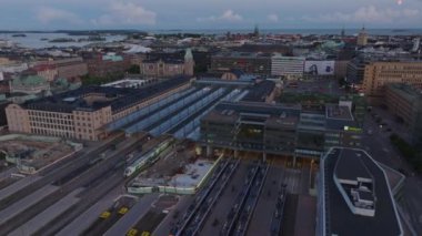 Merkez tren istasyonunun üzerinden uç. Trenler platformlarda duruyor. Akşam karanlığında şehir manzarası. Ulaşım ve lojistik konsepti. Helsinki, Finlandiya.