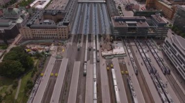 Demiryolu tesisinin yüksek açılı görüntüsü. Trenler şehirdeki merkez tren istasyonunda platformlarda duruyor. İnşaat devam ediyor. Ulaşım ve lojistik konsept. Helsinki, Finlandiya.