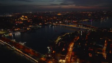 Akşam şehrinin panoramik görüntüsü. Aydınlatılmış sokakları ve su üzerinde köprüleri olan metropol. İstanbul, Türkiye.