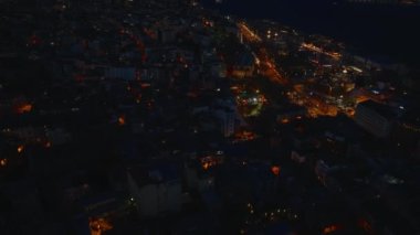 Şehir merkezindeki binaların yüksek açılı manzarası. Arka planda aydınlatılmış Boğaz Köprüsü olan gece manzarasını yukarı kaldır. İstanbul, Türkiye.