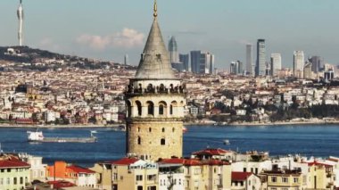 Tarihi Galata Kulesi 'nde eski turistik yerleri dolaş. Arka planda kentsel çevre ile parallaks etkisi. İstanbul, Türkiye.