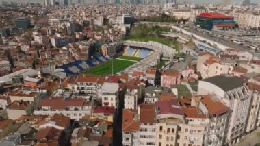 Yoğun şehir gelişimiyle çevrili futbol stadyumunun hava görüntüleri. Kentsel yerleşim yerlerindeki binalar. İstanbul, Türkiye.