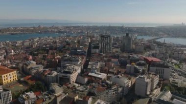 İleri, şehrin üzerinde uçar. Şehir merkezindeki modern yüksek binalar ve eski evlerin karışımı. Altın saatinde şehir manzarası. İstanbul, Türkiye.