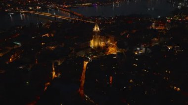 Galata Kulesi 'nin geceye ışıldayan yüksek açılı görüntüsü. Yukari egilerek aksam manzarasini göster. İstanbul, Türkiye.