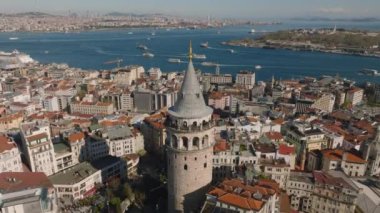 Popüler turistik yerleri ziyaret eden insanların havadan yükselen görüntüleri. Güneşli bir günde Galata Kulesi ve çevresindeki binalar. İstanbul, Türkiye.